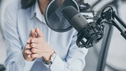 Woman speaking into a podcasting microphone